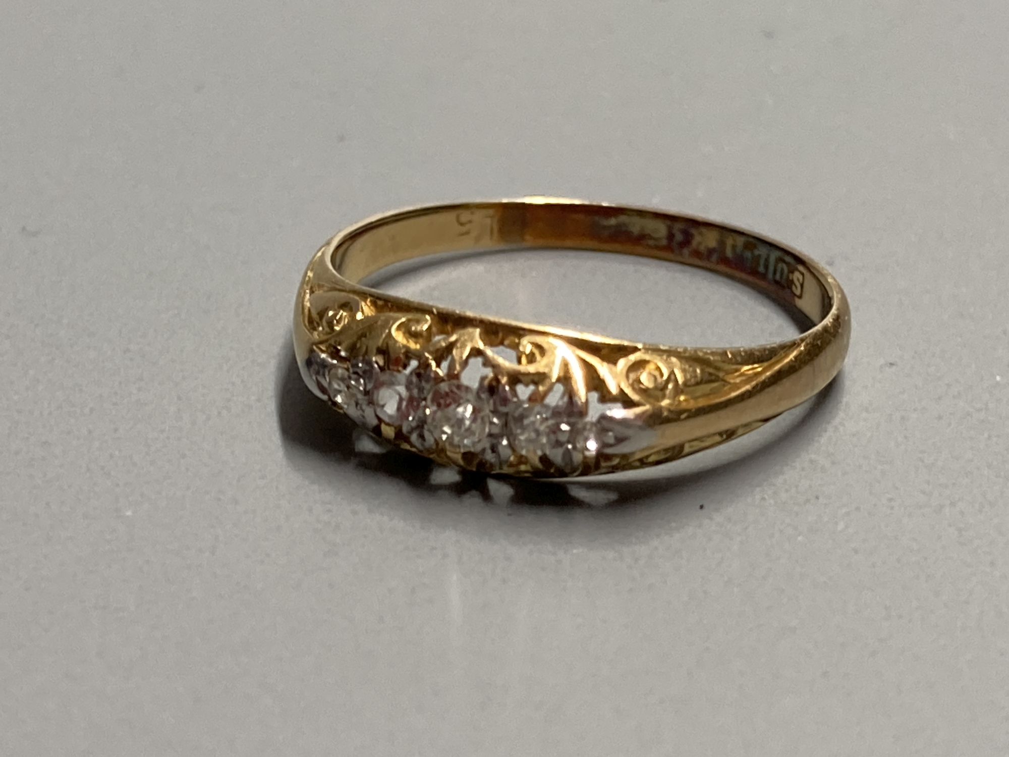 An early 20th century 18ct gold and graduated five stone diamond ring, size O, gross 2.1 grams.